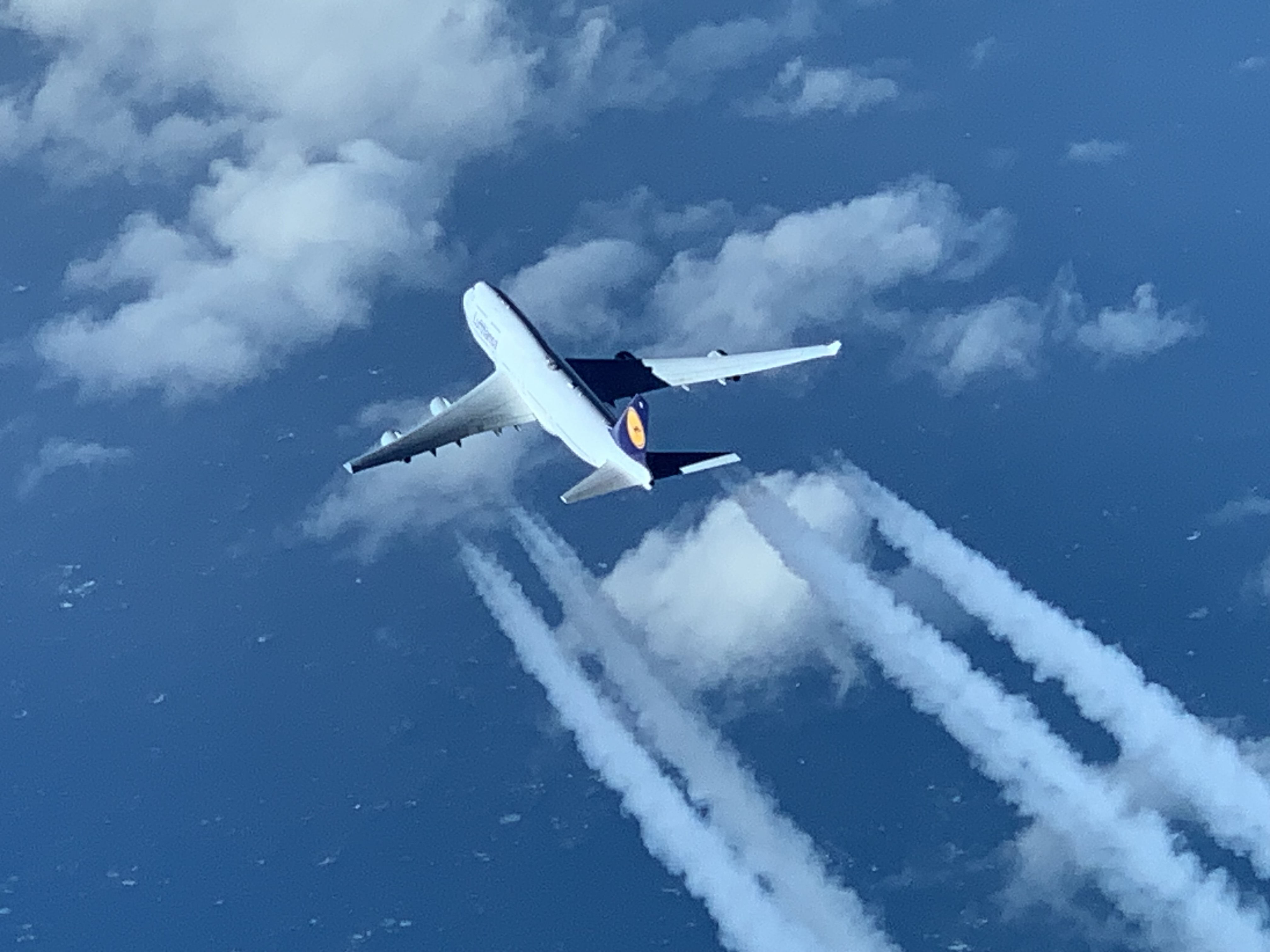 Aircraft climbing and leaving contrails